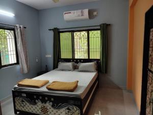 a bedroom with a bed in a room with windows at TPF 3BHK VILLA ALIBAUG in Alibaug