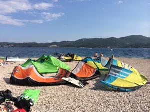 a group of kites on a beach near the water at Eco Sunshine Apartments Lumbarda in Lumbarda