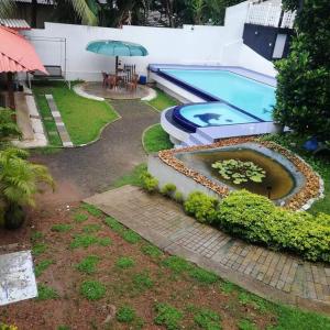 a swimming pool with a table and an umbrella at Elliot Nature Resort in Galle