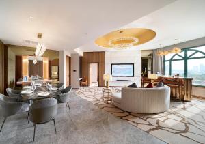 Sunway Resort Hotel في كوالالمبور: غرفة معيشة مع طاولة وكراسي وغرفة طعام