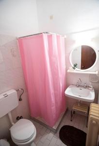 baño con cortina de ducha rosa y lavamanos en Koukonas, en Galaxidhion
