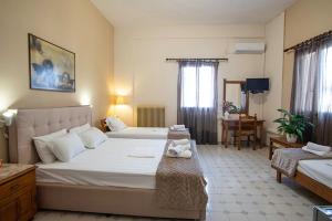 Ένα ή περισσότερα κρεβάτια σε δωμάτιο στο Ξενοδοχείο Κούκoνας
