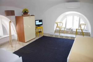 sala de estar con mesa, sillas y alfombra negra en LA CAMBUSA - In riva al mare!, en Maiori