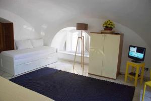Un dormitorio con una cama y un televisor en una habitación. en LA CAMBUSA - In riva al mare!, en Maiori