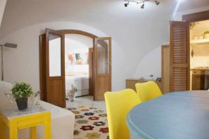 a dining room with a blue table and yellow chairs at LA CAMBUSA - In riva al mare! in Maiori