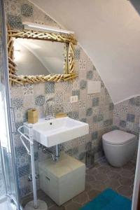 Un baño con lavabo, inodoro y espejo. en LA CAMBUSA - In riva al mare!, en Maiori