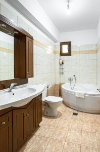 a bathroom with a tub and a sink and a toilet at 4 Seasons Home in Alexandroupoli