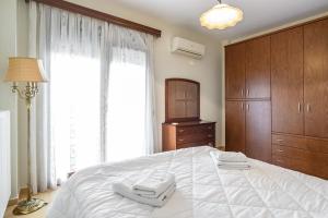 sypialnia z dużym łóżkiem z dwoma ręcznikami w obiekcie 4 Seasons Home w Aleksandropolis