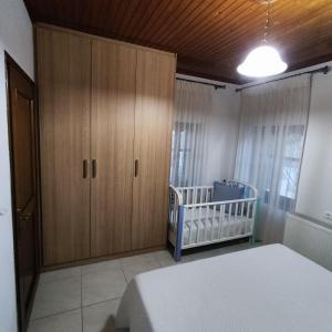 sypialnia z łóżkiem, szafką i łóżeczkiem dziecięcym w obiekcie VILLA KATERINA w mieście Tríkala