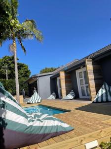 a house with a wooden deck and a swimming pool at The Door RSA Fifty-Four in Plettenberg Bay