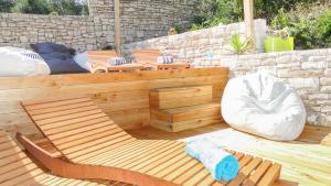 a wooden patio with chairs and a bean bag chair at Eco Sunshine Apartments Lumbarda in Lumbarda