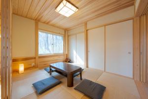 ein Wohnzimmer mit einem Tisch und einem Fenster in der Unterkunft スイートヴィラ 那須高原カシェット in Nasu