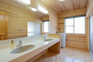 ein Badezimmer mit zwei Waschbecken und einem großen Spiegel in der Unterkunft スイートヴィラ 那須高原カシェット in Nasu