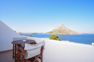 a table and chairs on a balcony overlooking the ocean at Apollonia Hotel in Masouri