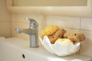a basket of cookies sitting on a sink next to a faucet at Apollonia Hotel in Masouri