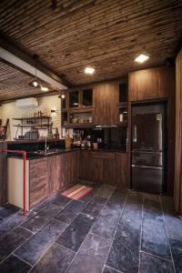 バヴィにあるMyBinsu Villa - Venue Travelのキッチン(木製キャビネット、黒い冷蔵庫付)