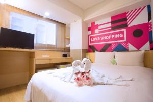 a bedroom with a white bed with a love shopping sign on it at Ximen Citizen Hotel in Taipei