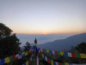 a row of colorful flags on a hill at sunset at Dubochaur Rest house & homestay in Nagarkot