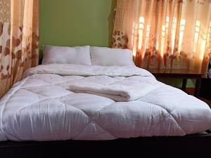 a large white bed sitting in a room at Dubochaur Rest house & homestay in Nagarkot