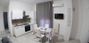 uma cozinha com uma mesa com cadeiras e um lavatório em Bergamo Centro Residence em Bérgamo