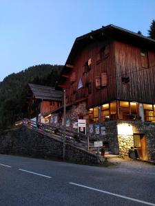 duży drewniany budynek przy drodze w obiekcie Auberge de Jeunesse HI La Clusaz w mieście Clusaz