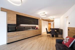 eine Küche und ein Wohnzimmer mit Sofa und Tisch in der Unterkunft La Dila Dolomiti Mountain Lodge in Andalo