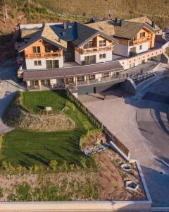 an aerial view of a large house with a yard at La Dila Dolomiti Mountain Lodge in Andalo