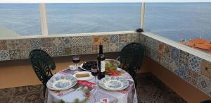 stół z jedzeniem i butelką wina na balkonie w obiekcie Apartamento Romantico w Caniço