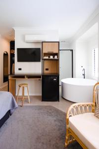 a bathroom with a bath tub and a large room with a bed at Chimes Spa Retreat in Denmark