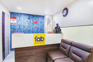 浦那FabExpress Galaxy Apartments - Lohegaon chowk的一间配有沙发和时钟的等候室