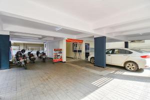 浦那FabExpress Galaxy Apartments - Lohegaon chowk的车库内停放汽车和摩托车