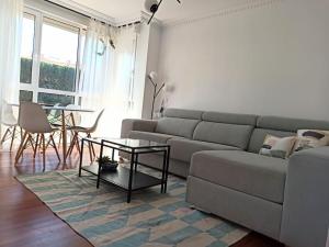 sala de estar con sofá y mesa en Bajo con jardín privado, en Santander