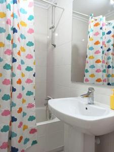 baño con lavabo y cortina de ducha en Bajo con jardín privado, en Santander
