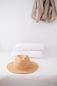 un sombrero de paja sentado en la parte superior de una cama en Chimes Spa Retreat, en Denmark