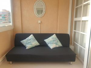 アリカンテにあるPiso para vacaciones en Alicanteの黒いソファ(枕2つ付)