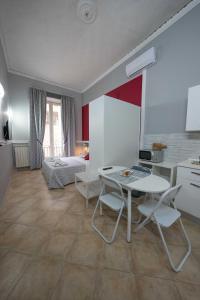 um quarto com uma mesa e cadeiras e uma cama em Cattedrale Duomo 77 Apartments By Dimorra em Nápoles