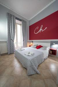 um quarto com uma cama grande e uma parede vermelha em Cattedrale Duomo 77 Apartments By Dimorra em Nápoles
