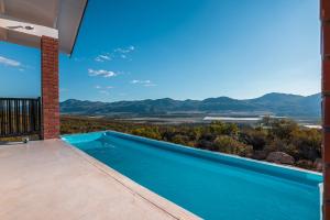 a swimming pool in a house with a view of the mountains at Wolfkop Nature Reserve in Citrusdal