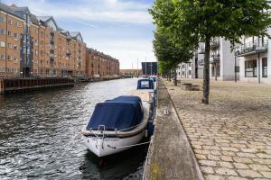 a boat is docked in a canal next to buildings at Scandi-Hygge 2 bedroom apartment in charming Christianshavn in Copenhagen