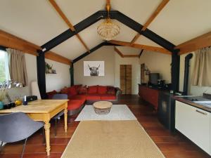 ein Wohnzimmer mit einem roten Sofa und einem Tisch in der Unterkunft Vakantiehuis Meerzicht in Nederhemert