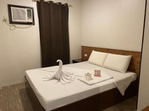 a room with a bed with a swan on it at Traveler's Inn Bajada in Davao City