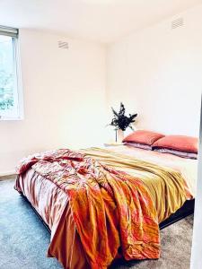 a bedroom with a bed with a colorful blanket on it at Two bedroom South Melbourne Apartment on Montague in Melbourne