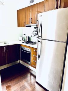 a kitchen with a white refrigerator and wooden cabinets at Two bedroom South Melbourne Apartment on Montague in Melbourne