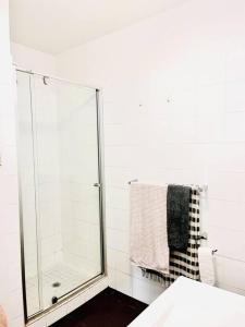 La salle de bains est pourvue d'une douche en verre et d'une serviette. dans l'établissement Two bedroom South Melbourne Apartment on Montague, à Melbourne