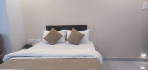 a bedroom with a bed with white sheets and pillows at Hotel Success Residency in Ghansoli