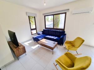 Liza Dream House في ترسيفانو: غرفة معيشة مع أريكة زرقاء وكرسيين