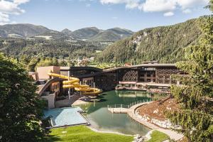 a resort with a pool and a water slide at Falkensteiner Family Resort Lido Superior in Chienes