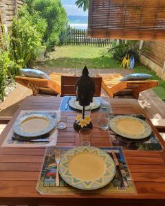 una mesa de madera con platos encima en Les Sternes 2 - Apt T2 pieds dans l'eau et jardin, en Trois Bassins