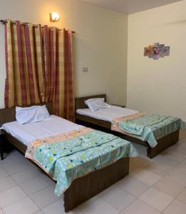 a bedroom with two beds and a window with curtains at Krimson Bricks Homestay in Varanasi