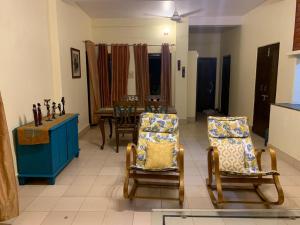 a living room with two chairs and a table at Krimson Bricks Homestay in Varanasi
